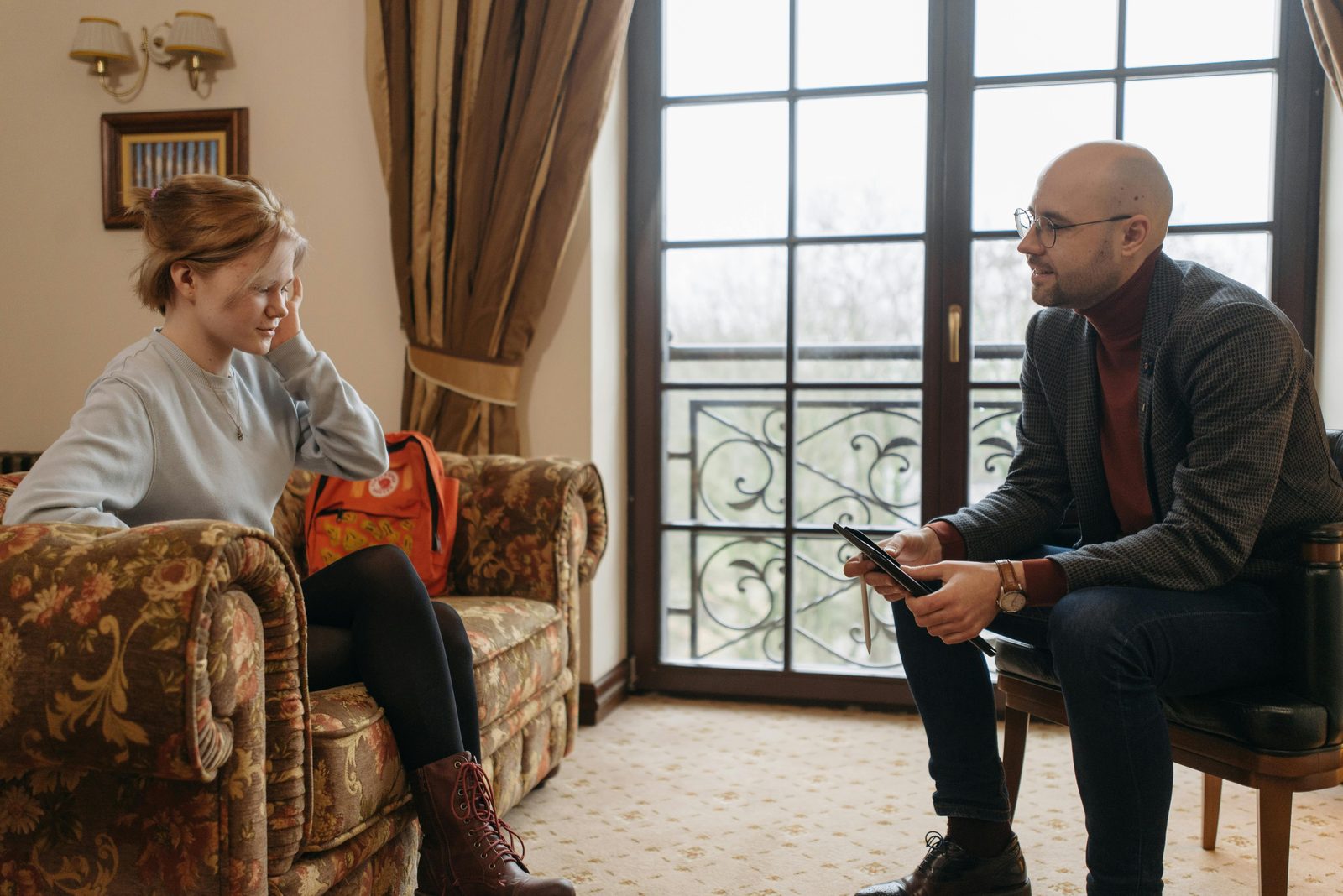 A mentor listening carefully to a young woman in a calm room